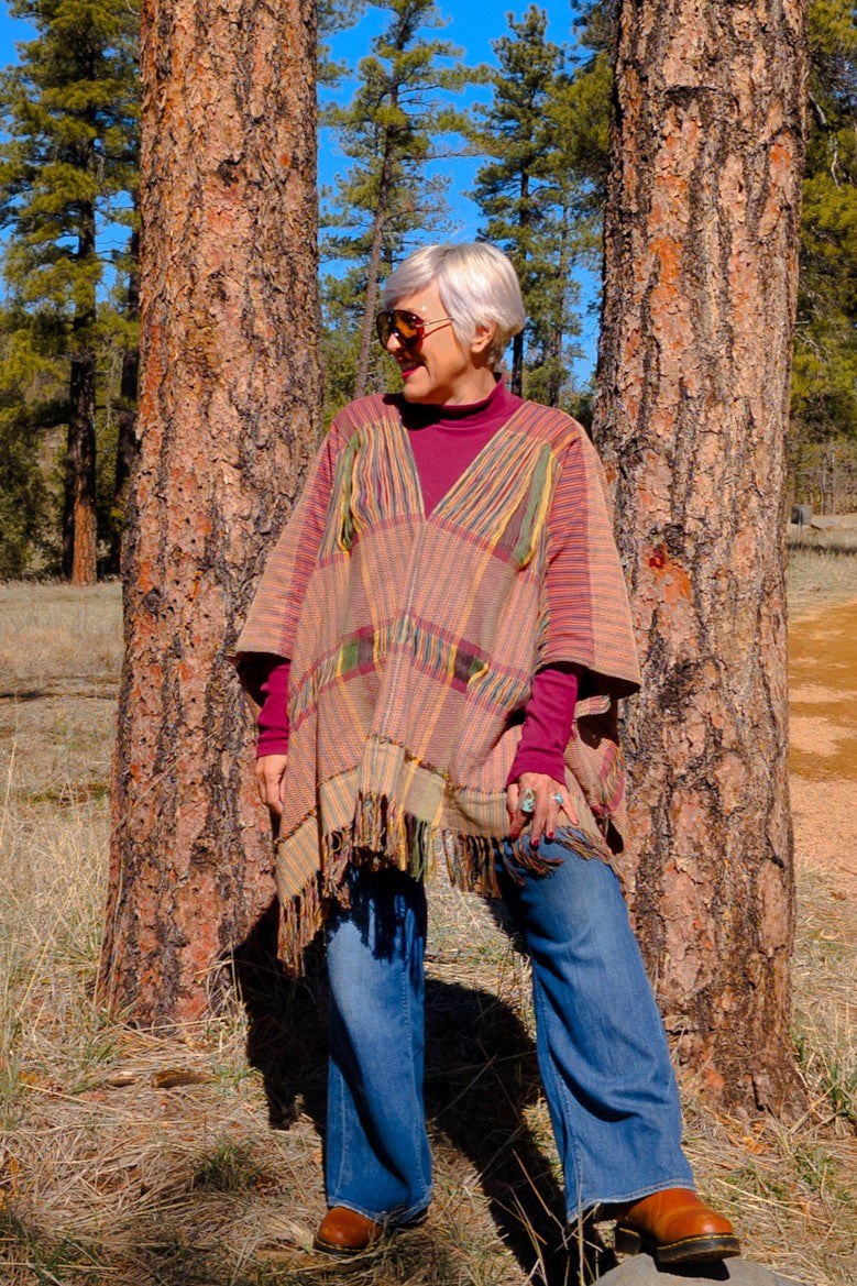 Poncho con textil 100% artesanal tejido en telar de pedal con deshuilados mediano en franjas en todo  lo alto. De corte oversize con cuello en V y flecos en la parte inferior.