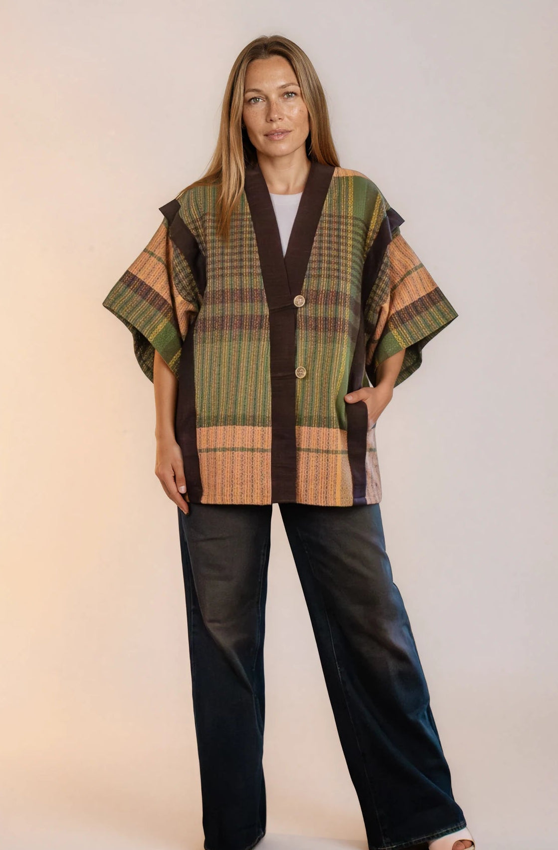 Saco laego abajo de la cadera, con mangas a los codos. Abierto del frente y con dos botones de estilo retro y bolsas en los laterales.