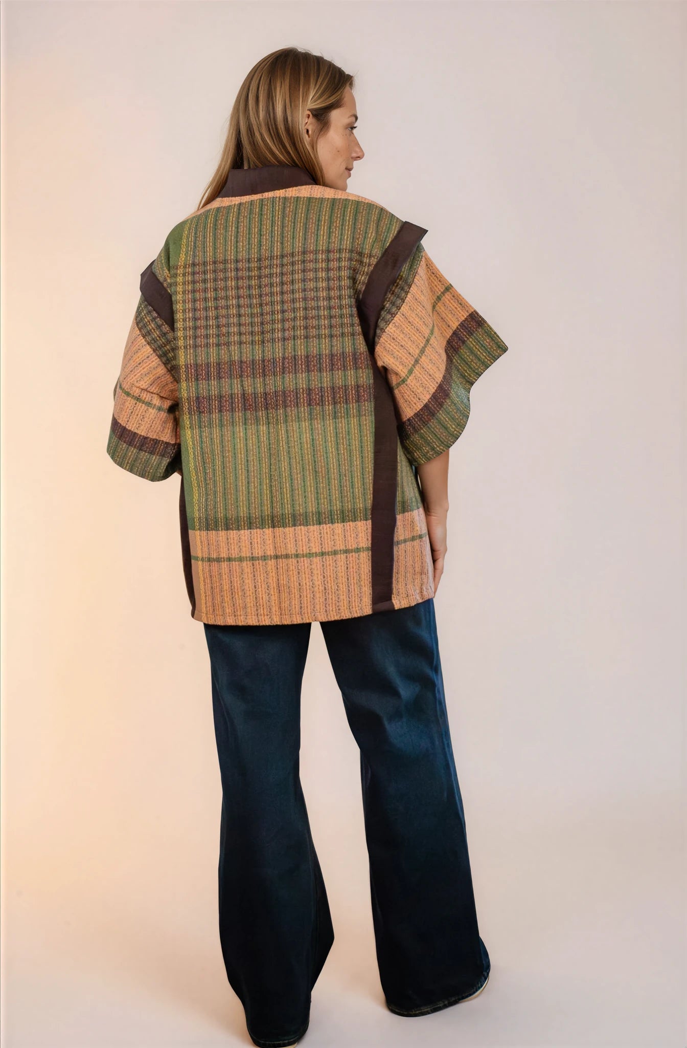 Saco laego abajo de la cadera, con mangas a los codos. Abierto del frente y con dos botones de estilo retro y bolsas en los laterales. Vista de espalda.